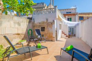 patio z krzesłami, stołami i ogrodzeniem w obiekcie Can Salas w mieście Porreres