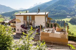 a house on a hill with mountains in the background at Appartements Sonneck in Funes