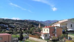 a group of houses on a hill with mountains in the background at Alloggio Lavanda in Diano San Pietro