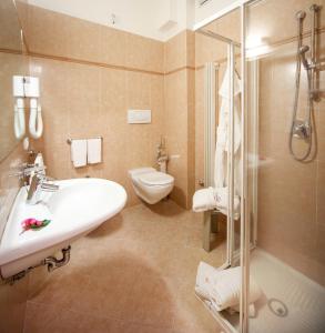 een badkamer met een wastafel, een toilet en een douche bij Hotel Doge in Milano Marittima