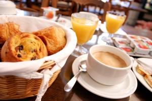 a basket of bread and a cup of coffee on a table at Hotel Du Tertre in Mont-Dol