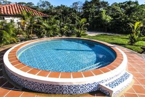 a large swimming pool in a yard with a house at Hotel Mastranto in Villavicencio