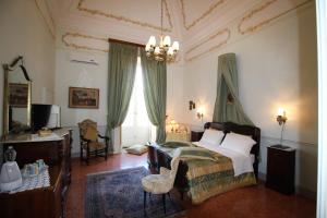 1 dormitorio con cama y lámpara de araña en Palazzo De Castro, en Squinzano