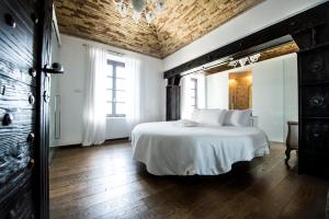 a bedroom with a white bed with a wooden ceiling at Faro Capo Spartivento in Chia