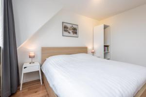 ベルゲンにあるGoudkust 3 'At Sea'のベッドルーム(白いベッド1台、鏡付)