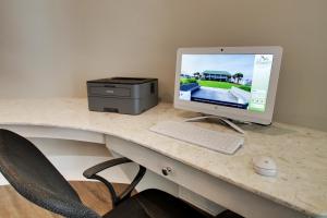 un monitor de ordenador y una impresora en un escritorio en Islander Hotel & Resort en Emerald Isle