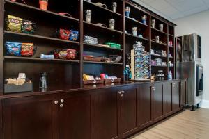 a bar in a room with a large wall of shelves at Islander Hotel & Resort in Emerald Isle