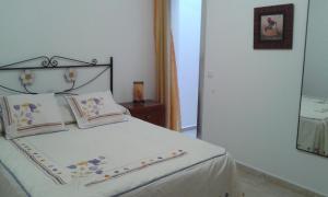 グラン・タラハルにあるPISO 3 DORMITORIOS EN GRAN TARAJAL con wifiのベッドルーム(鏡付きの白いベッド付)