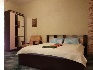 - une chambre avec un lit, une chaise et un miroir dans l'établissement Almaz hotel, à Saint-Pétersbourg