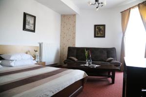 a hotel room with a bed and a couch at Zamek Camelot in Dębica