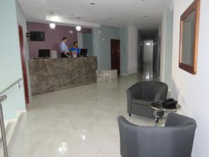 a lobby with two people standing at a counter at Hotel San Juan Periferico in Villahermosa
