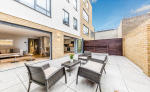 a patio with wicker chairs and a table at Lux St James Park Apartment Central London FREE WIFI by City Stay Aparts London in London
