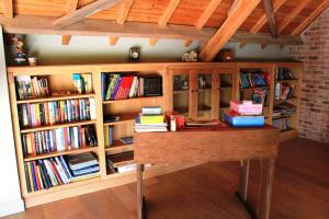a book shelf full of books in a room with a desk at B&B De Luyckhoek in Handzame
