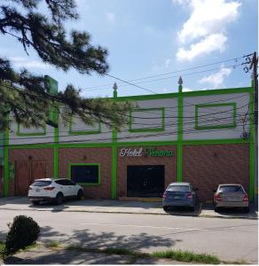 un edificio con dos coches estacionados frente a él en Hotel Verona, en San Pedro Sula