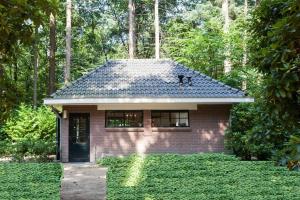 una piccola casa di mattoni in mezzo a una foresta di Bos Huisje a Putten