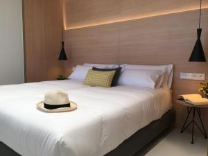 un letto bianco con un cappello sopra di Inside Bilbao Apartments a Bilbao