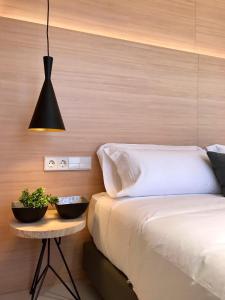 a bedroom with a bed and a table with a plant at Inside Bilbao Apartments in Bilbao