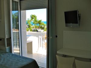 a bedroom with a sliding glass door with a view of the ocean at Hotel Residence HR CIVI in Tortoreto Lido