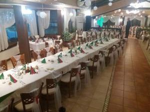 un gran salón de banquetes con mesas y sillas blancas en Kovanlika Hotel, en Razgrad