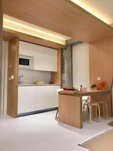 a kitchen with white cabinets and a wooden table at Inside Bilbao Apartments in Bilbao