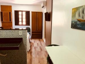 a room with a kitchen with a counter and a table at FLAT Estalagem 11 in Arraial do Cabo