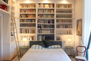 una camera con letto e librerie piene di libri di la stanza del filosofo a Napoli