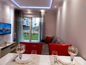 ein Esszimmer mit roten Stühlen und einem Tisch mit Weingläsern in der Unterkunft Na Grobli 014 in Breslau