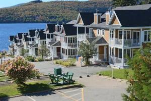a row of houses on the shore of a lake at Condo Lac Archambault 326 in Saint-Donat-de-Montcalm