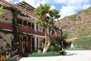 una casa con un árbol delante de ella en Hotel Fonda del Sol en Panajachel