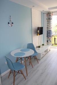 ウストカにあるApartamenty Baltico Ustkaのダイニングルーム(青い椅子2脚、テーブル付)