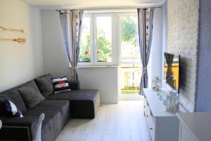 a living room with a couch and a window at Apartamenty Baltico Ustka in Ustka