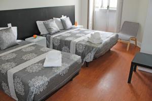 a bed room with two beds and a table at Lunar Guest House in Porto