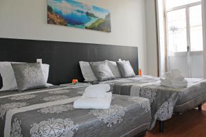 1 dormitorio con 2 camas y toallas. en Lunar Guest House, en Oporto