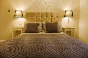 een slaapkamer met een groot bed met 2 lampen bij St John’s Cottage – Simple2let Serviced Apartments in Halifax