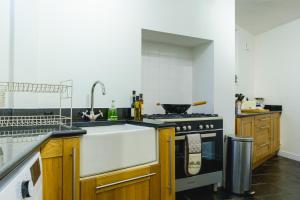a kitchen with a sink and a stove top oven at St John’s Cottage – Simple2let Serviced Apartments in Halifax
