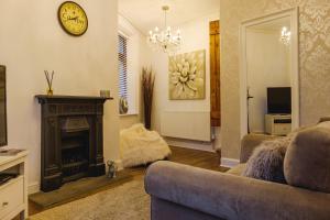 sala de estar con sofá y chimenea en St John’s Cottage – Simple2let Serviced Apartments en Halifax