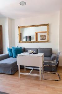 sala de estar con sofá y mesa en Apartamentos Elvira 21, en Granada