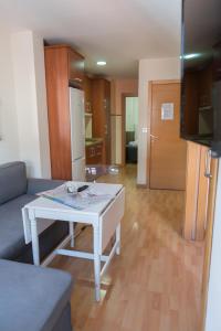 sala de estar con mesa blanca y cocina en Apartamentos Elvira 21, en Granada