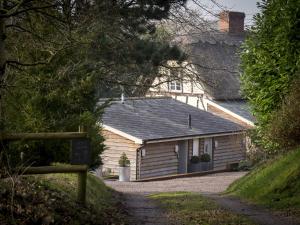 uma cabana de madeira com uma placa à frente. em The Steppes Holiday Cottages em Hereford