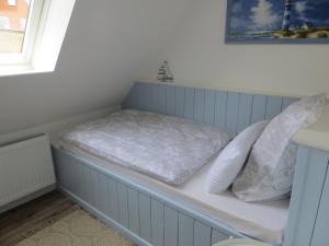 a bed sitting in a room with a window at Ferienhaus Käte in Friedrichstadt