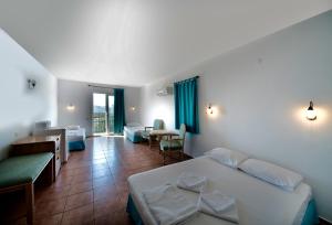 a hotel room with two beds and a balcony at Miramar Pansiyon in Kaş