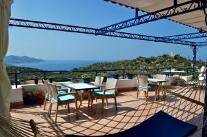 a patio with tables and chairs on a balcony at Miramar Pansiyon in Kaş
