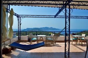 a patio with chairs and a table and a view of the ocean at Miramar Pansiyon in Kaş