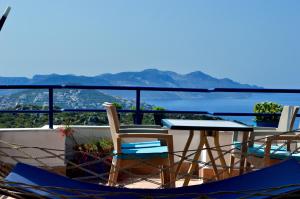 a table and chairs on a balcony with a view at Miramar Pansiyon in Kaş