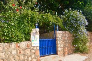 a blue gate next to a stone wall at Miramar Pansiyon in Kaş