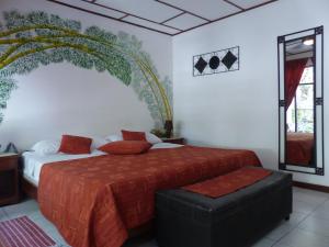 a bedroom with a large bed with a red bedspread at Hotel Villa Romantica in Manuel Antonio +39 photos