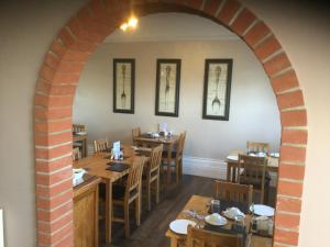 an archway in a restaurant with wooden tables and chairs at Beaumont House in Great Yarmouth