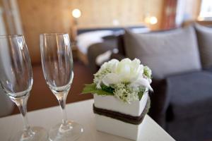 a table with two wine glasses and a cake and flowers at Hotel Cabana in Grindelwald