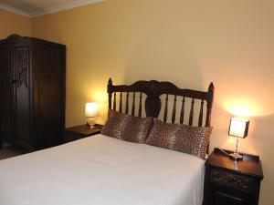 a bedroom with a bed with two night stands and two lamps at Rose of Sharon in Amanzimtoti