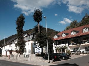 a white building with a tree in front of it at Hotel-Gasthof Hüttensteinach in Sonneberg